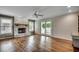 Spacious living room with hardwood floors, brick fireplace, and sliding glass door to porch at 3334 Cedar Creek Run, Little River, SC 29566