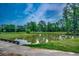 Picturesque golf course landscape featuring a serene pond reflecting the sky, surrounded by lush greenery at 3334 Cedar Creek Run, Little River, SC 29566
