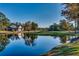 Picturesque golf course view with a serene pond reflecting the clear blue sky and surrounding trees at 3334 Cedar Creek Run, Little River, SC 29566