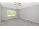 Spacious primary bedroom with large windows, tray ceiling, and plush carpeting throughout at 3539 Harrelson Ave., Loris, SC 29569