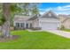 Charming one-story home with well-manicured lawn and a two-car garage on a sunny day at 3539 Harrelson Ave., Loris, SC 29569