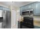 The kitchen features blue cabinets, stainless steel appliances, lots of storage, and natural light at 4013 Blackwolf Dr., Myrtle Beach, SC 29579