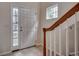 Bright entryway features tile flooring, a sidelight window, and a staircase with wood railing at 422 South Poplar Dr., Surfside Beach, SC 29575