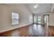 Bright living room with wood flooring, two windows, and sliding glass doors that lead to the backyard at 422 South Poplar Dr., Surfside Beach, SC 29575