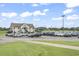 Exterior view of a two-story building with a spacious parking lot and manicured lawns under a sunny sky at 4574 Girvan Dr. # D, Myrtle Beach, SC 29579