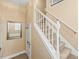 Classic staircase with white railings and carpeted steps leading to the upper level, next to a paneled wall at 4574 Girvan Dr. # D, Myrtle Beach, SC 29579