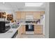 Functional kitchen featuring light wood cabinetry, a white microwave and standard appliances at 4648 Greenbriar Dr. # D2, Little River, SC 29566