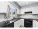 Well-lit kitchen with white cabinets, black countertops, stainless sink and appliances at 502 Garden Dr., Surfside Beach, SC 29575