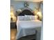 Bedroom with a queen-size bed with decorative pillows, two lamps and a window at 523 S Ocean Blvd. # 705, North Myrtle Beach, SC 29582