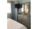 Bedroom with dresser and mirror, next to a window with silver curtain at 523 S Ocean Blvd. # 705, North Myrtle Beach, SC 29582
