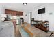 Comfortable living room and kitchen area featuring a couch, dark wood cabinets, and a TV at 5409 North Ocean Blvd. # 106/7108, North Myrtle Beach, SC 29582