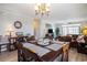Elegant dining area with a large wooden table, chairs, chandelier, and views into the living room at 5751 Oyster Catcher Dr. # 315, North Myrtle Beach, SC 29582