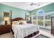 Serene main bedroom with a four-poster bed, ceiling fan, and a large window at 5751 Oyster Catcher Dr. # 315, North Myrtle Beach, SC 29582
