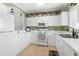 Well-lit kitchen showcases white cabinetry, modern appliances, and tiled floor at 5825 Catalina Dr. # 124, North Myrtle Beach, SC 29582