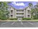 Three-story condo complex, ample parking, and mature trees create an inviting, peaceful setting at 598 Blue Stem Dr. # 52E, Pawleys Island, SC 29585