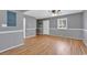 Finished living room with wood flooring features painted gray walls with white trim, a window, and a white door at 633 Sparrow Dr. # B, Surfside Beach, SC 29575