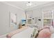 A well-lit bedroom with a plush bed, two windows, TV on the dresser and a vanity at 6420 Longwood Dr., Murrells Inlet, SC 29576