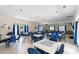 Spacious clubhouse room featuring tables, chairs, and large windows for ample natural light at 6420 Longwood Dr., Murrells Inlet, SC 29576