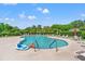 Outdoor community pool with lounge chairs, umbrellas and mature landscaping in the background at 6420 Longwood Dr., Murrells Inlet, SC 29576