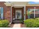 Inviting entryway featuring a brick facade, covered porch, decorative wreath and manicured landscaping at 6420 Longwood Dr., Murrells Inlet, SC 29576