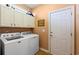 Functional laundry room equipped with modern washer and dryer units and upper cabinets at 6420 Longwood Dr., Murrells Inlet, SC 29576