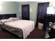 Bedroom with dark curtains, a TV on a black dresser, and a patterned comforter at 6805 Creekwatch Rd. # 105, Myrtle Beach, SC 29588
