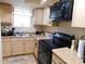 Efficient kitchen with light wood cabinets and black appliances at 6805 Creekwatch Rd. # 105, Myrtle Beach, SC 29588