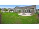 Green backyard with a circular patio featuring a fire pit and seating area at 720 Little Fawn Way, Myrtle Beach, SC 29579