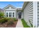 Stylish home exterior with a black front door, large window, and manicured landscaping at 720 Little Fawn Way, Myrtle Beach, SC 29579
