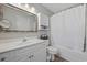 Clean bathroom features white vanity, framed mirror, storage cabinet, and a shower-tub combination with a white curtain at 721 Dunlon Ct., Myrtle Beach, SC 29588