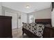 Cozy bedroom offers a dark wood sleigh bed, ceiling light, wood flooring, and plentiful closet space at 721 Dunlon Ct., Myrtle Beach, SC 29588