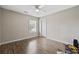 Simple bedroom with light wood floors, a window, a ceiling fan, and a door, with belongings on the floor at 721 Dunlon Ct., Myrtle Beach, SC 29588