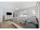 Serene main bedroom featuring a bright window, ceiling fan, light wood floors, and white furniture at 721 Dunlon Ct., Myrtle Beach, SC 29588