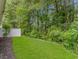 Well-manicured backyard featuring lush green grass, mature trees, and a white fence, providing privacy at 751 Painted Bunting Dr. # E, Murrells Inlet, SC 29576