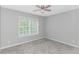 This bedroom has gray walls, carpet and a ceiling fan with a window that brings in lots of light at 751 Painted Bunting Dr. # E, Murrells Inlet, SC 29576