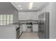 Kitchen with stainless appliances, white cabinets, updated countertops, and modern flooring at 751 Painted Bunting Dr. # E, Murrells Inlet, SC 29576