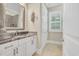 Bathroom featuring a vanity with granite countertop, white cabinets, decorative mirror, and tiled floors at 81 Cascade Dr., Murrells Inlet, SC 29576