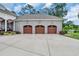 A three-car garage showcases arched doors and well-manicured landscaping, enhancing curb appeal at 81 Cascade Dr., Murrells Inlet, SC 29576