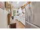 Well-organized laundry room with stainless steel refrigerator, white cabinets, washer, and wooden bench at 81 Cascade Dr., Murrells Inlet, SC 29576