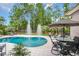 Relaxing backyard pool with fountains, elegant patio furniture, and a backdrop of lush, mature trees at 81 Cascade Dr., Murrells Inlet, SC 29576