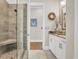 Modern tiled shower with a bench, glass door, and adjacent vanity with granite countertop and white cabinets at 81 Cascade Dr., Murrells Inlet, SC 29576