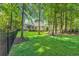 Lush backyard surrounded by mature trees, featuring a black fence and vibrant green lawn at 840 Jeter Ln., Myrtle Beach, SC 29588