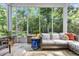 Relaxing sunroom with a decorative couch, tiled floors, and large windows overlooking the lush backyard at 840 Jeter Ln., Myrtle Beach, SC 29588