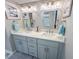 Bright bathroom featuring double sinks, modern fixtures, and blue-themed decor at 9840 Queensway Blvd. # 227, Myrtle Beach, SC 29572
