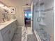Bathroom with double sinks, a glass shower, and an open doorway leading to a bedroom at 9840 Queensway Blvd. # 227, Myrtle Beach, SC 29572
