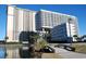 Stunning high-rise condo buildings offer beautiful balconies and lush landscaping near a tranquil pond at 9840 Queensway Blvd. # 227, Myrtle Beach, SC 29572