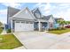 Charming home with a two-car garage, covered front porch with seating, and a well-maintained lawn at 1008 Mary Read Dr., North Myrtle Beach, SC 29582