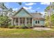 Back exterior view of home showcasing screened in porch, patio, and lush landscaping at 103 Pigeon Forge Ct., Murrells Inlet, SC 29576