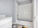 Bathroom with white tiled shower, tub, modern fixtures, vanity, and gray tile flooring at 105 Michau Rd., Georgetown, SC 29440