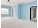 Large, open bedroom with blue walls, white trim, natural light, and doorways to other rooms at 105 Michau Rd., Georgetown, SC 29440